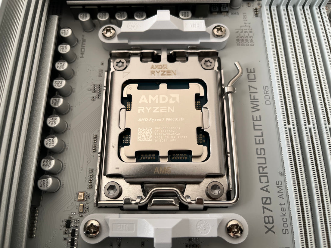 Processeur AMD Ryzen 7 9800X3D installé sur une carte mère Gigabyte X870 AORUS ELITE WIFI 7 ICE, mettant en valeur le socket AM5 et le design épuré de la carte mère DDR5